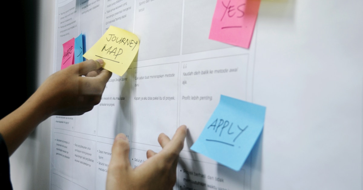person holding yellow sticky notes