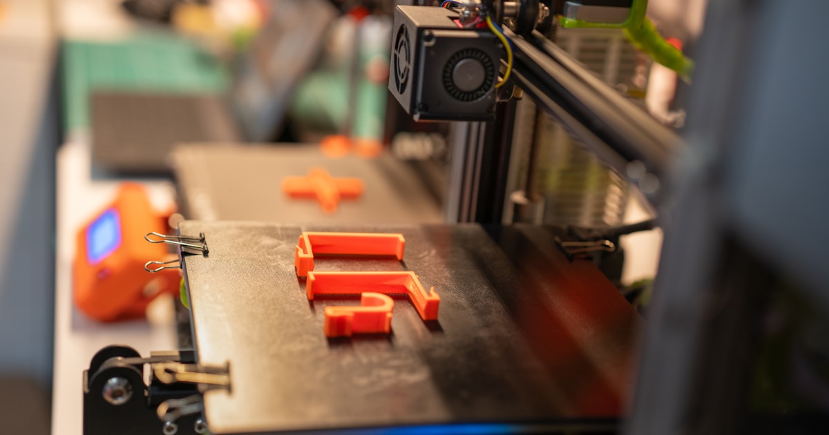 a close up of a machine with orange pieces on it