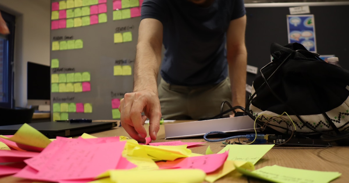 a man is working on a project with sticky notes